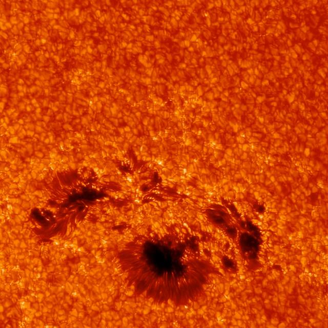 High-resolution image showing solar granulation pattern and sunspot group (Sacramento Peak Observatory)