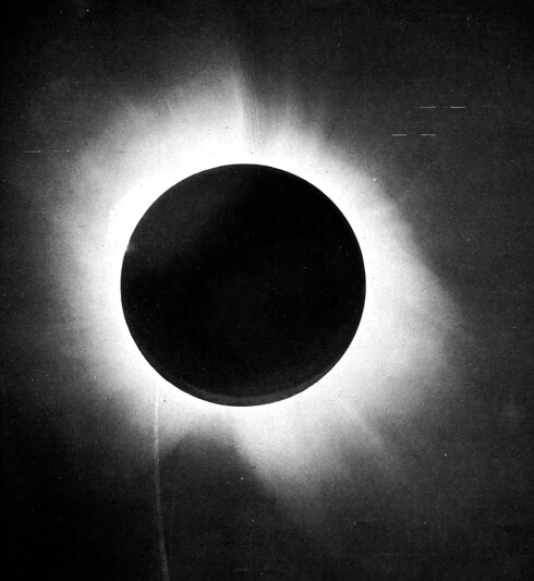Positive print of the 29 May 1919 total solar eclipse from the Príncipe expedition, showing the Sun's corona streaming outward from the black disc of the Moon; a few faint Hyades stars are visible in the surrounding sky.