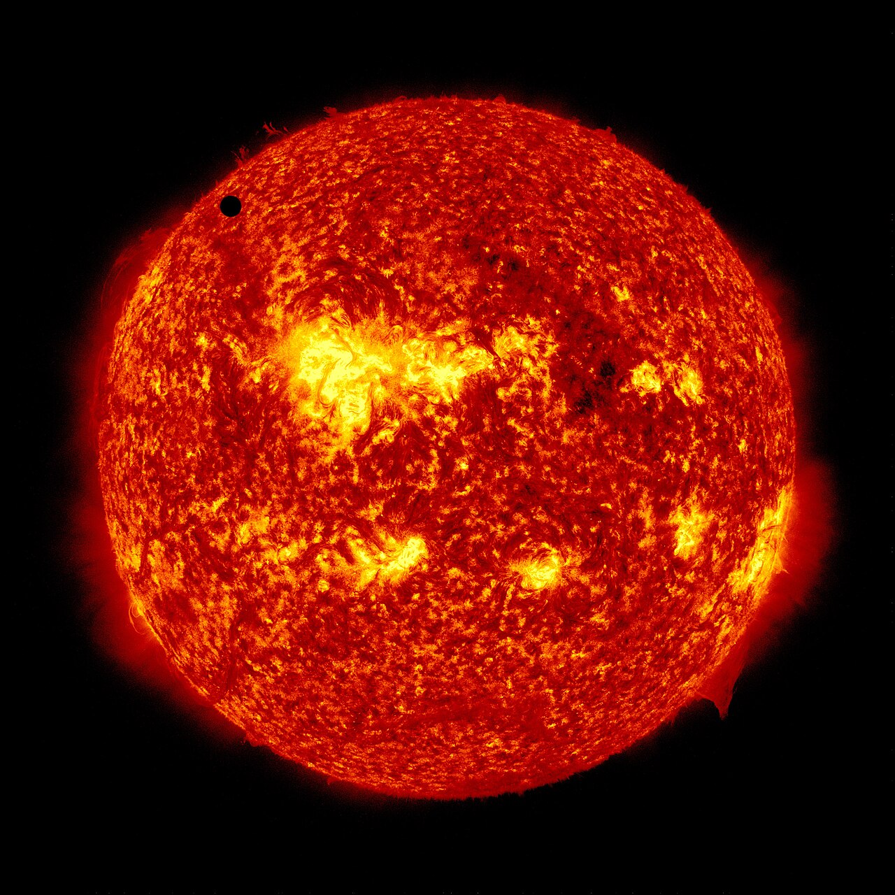 The 2012 transit of Venus photographed by NASA's Solar Dynamics Observatory in 304-Angstrom ultraviolet light. Venus appears as a perfectly black, sharp-edged disc against the orange textured face of the Sun.